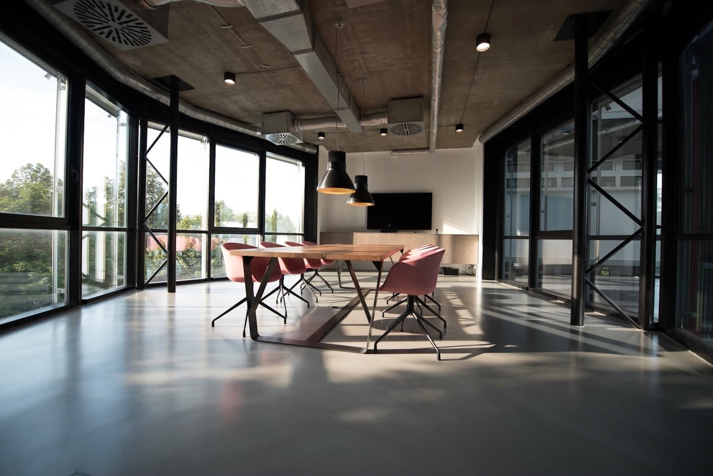 Modern commercial office interior with exposed ceiling services and ventilation ductwork